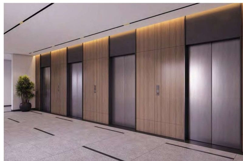 The double-height tower lobby at Myscape Palma clad in natural stone with four passenger lifts