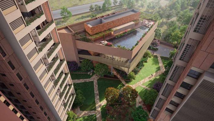 The three-floor clubhouse at Myscape Songs of the Sun seen from above, with the terrace swimming pool and multipurpose deck.