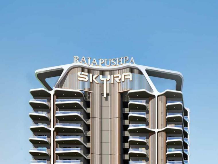 Crown of a Rajapushpa Skyra tower at Neopolis showing the signage band, sky-level frame and balcony stack.