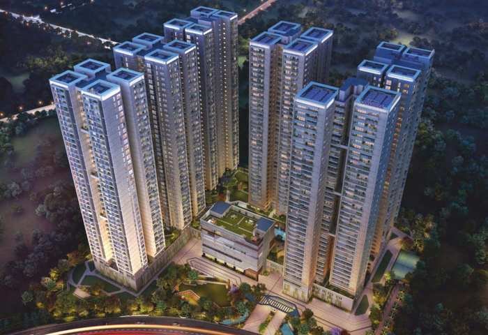 Sattva LakeRidge six towers lit at night above the clubhouse podium at Neopolis, Kokapet